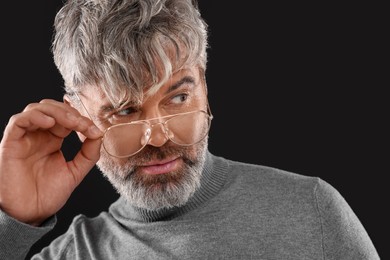 Photo of Portrait of confident man with beautiful hairstyle on black background