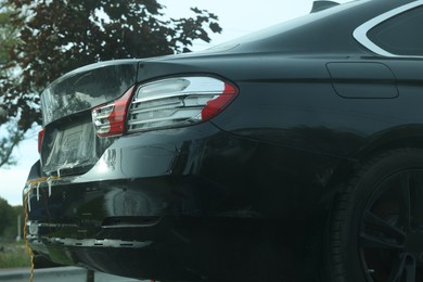 Photo of Modern black car with scratch outdoors, closeup view