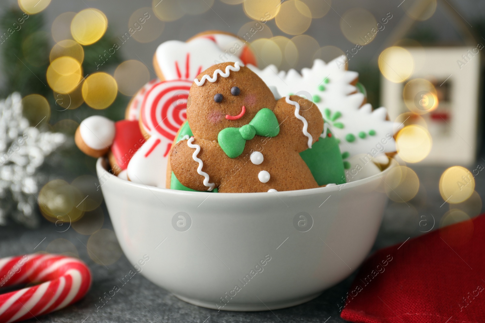Image of Tasty decorated Christmas cookies in bowl on table. Bokeh effect