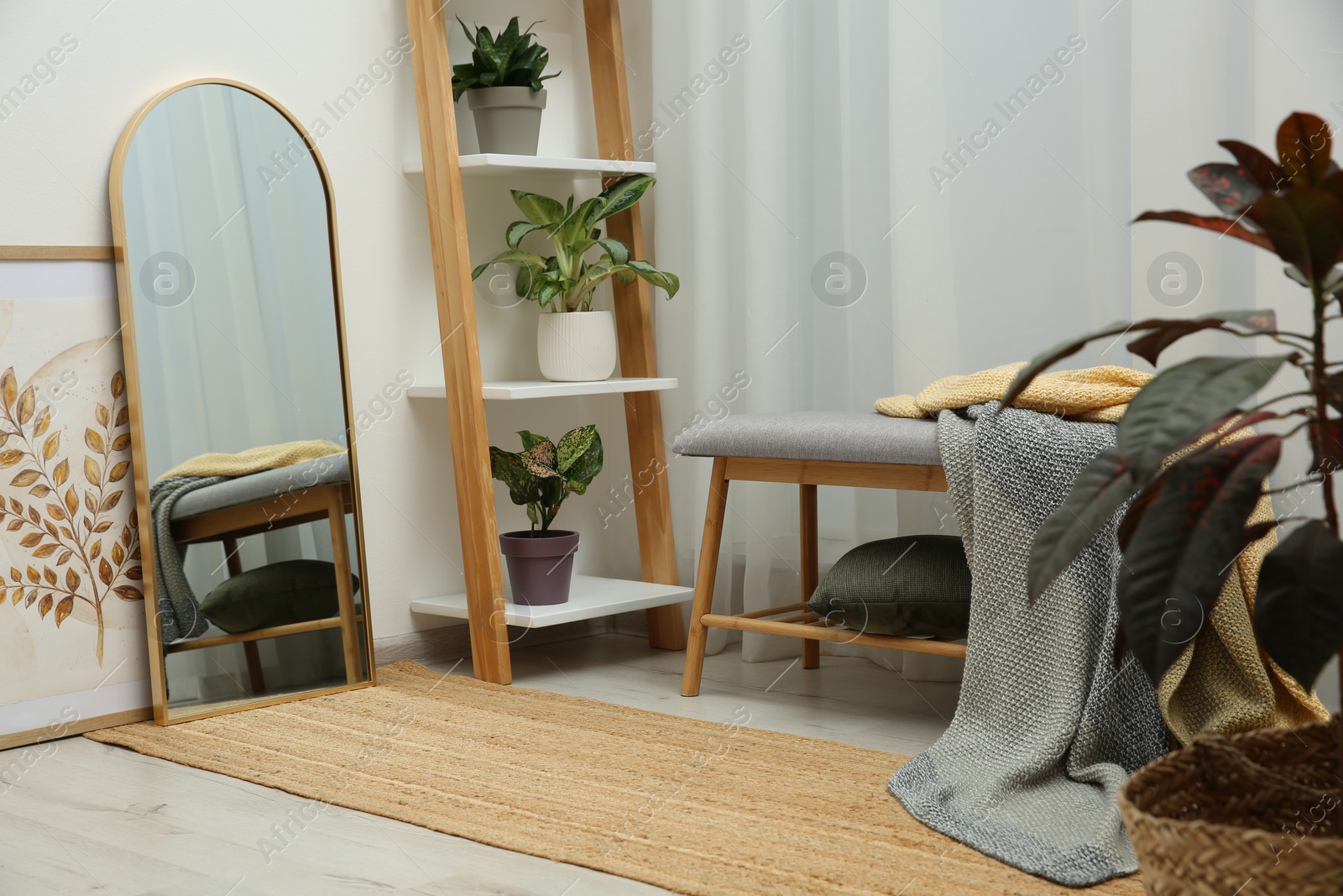Photo of Room interior with wooden furniture, mirror and houseplants. Stylish accessories