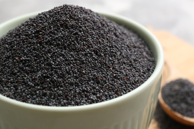 Photo of Poppy seeds in white ceramic bowl, closeup