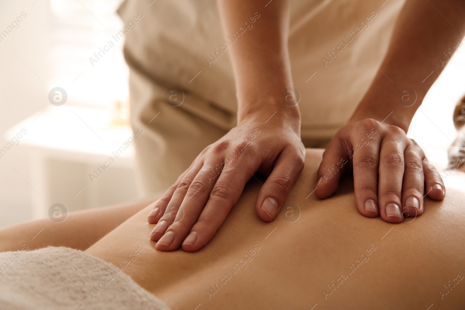 Photo of Young woman receiving back massage in spa salon, closeup