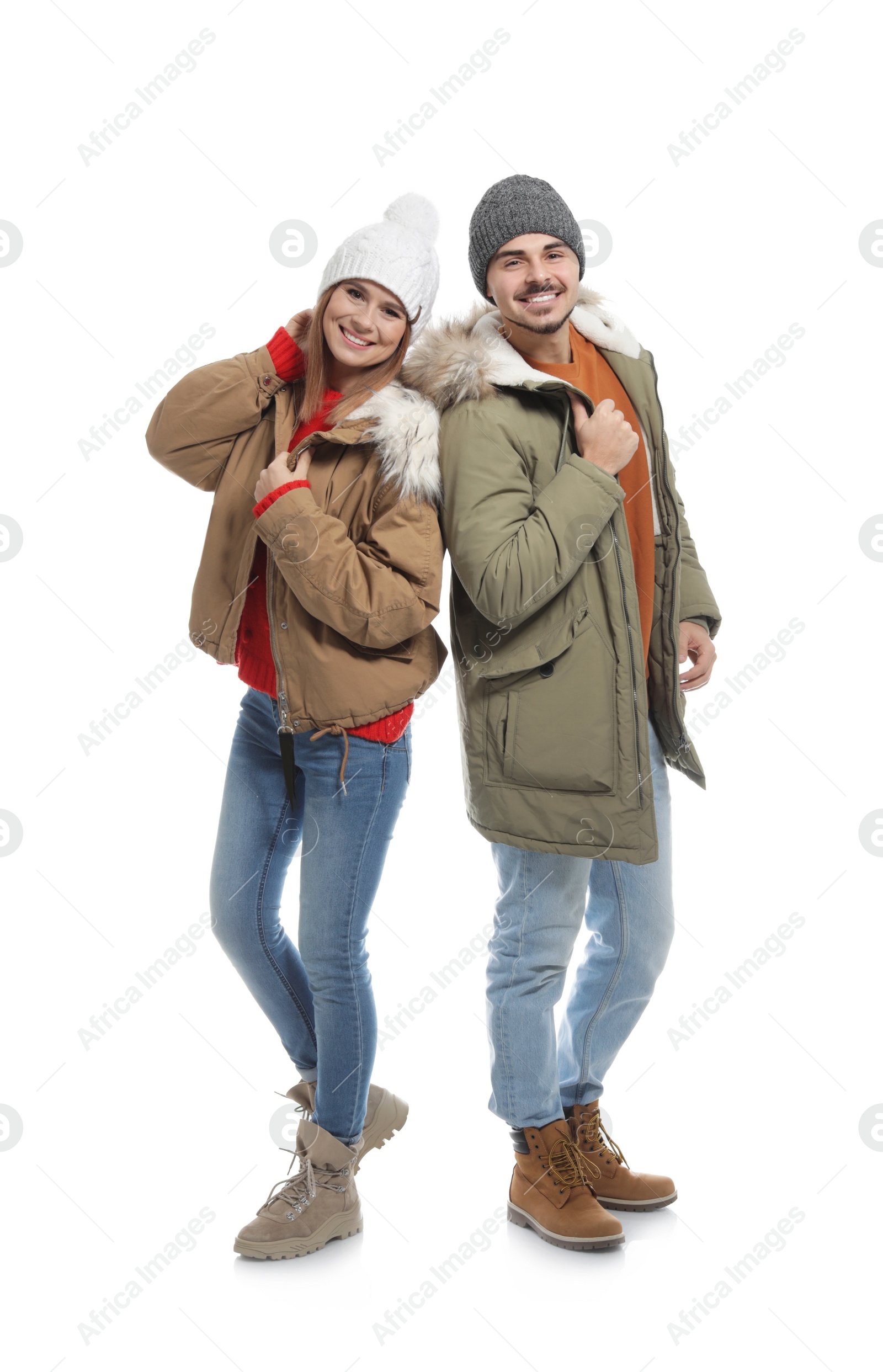 Photo of Young couple wearing warm clothes on white background. Ready for winter vacation