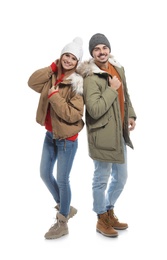 Young couple wearing warm clothes on white background. Ready for winter vacation