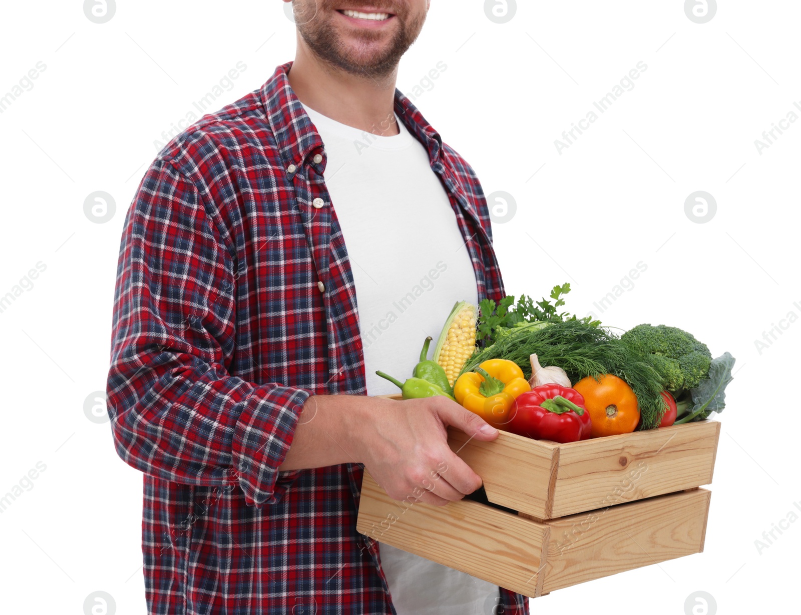 Photo of Harvesting season. Happy farmer holding wooden crate with vegetables on white background, closeup