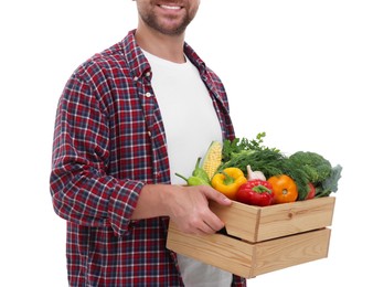 Harvesting season. Happy farmer holding wooden crate with vegetables on white background, closeup