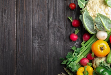 Flat lay composition with assortment of fresh vegetables on wooden table. Space for text