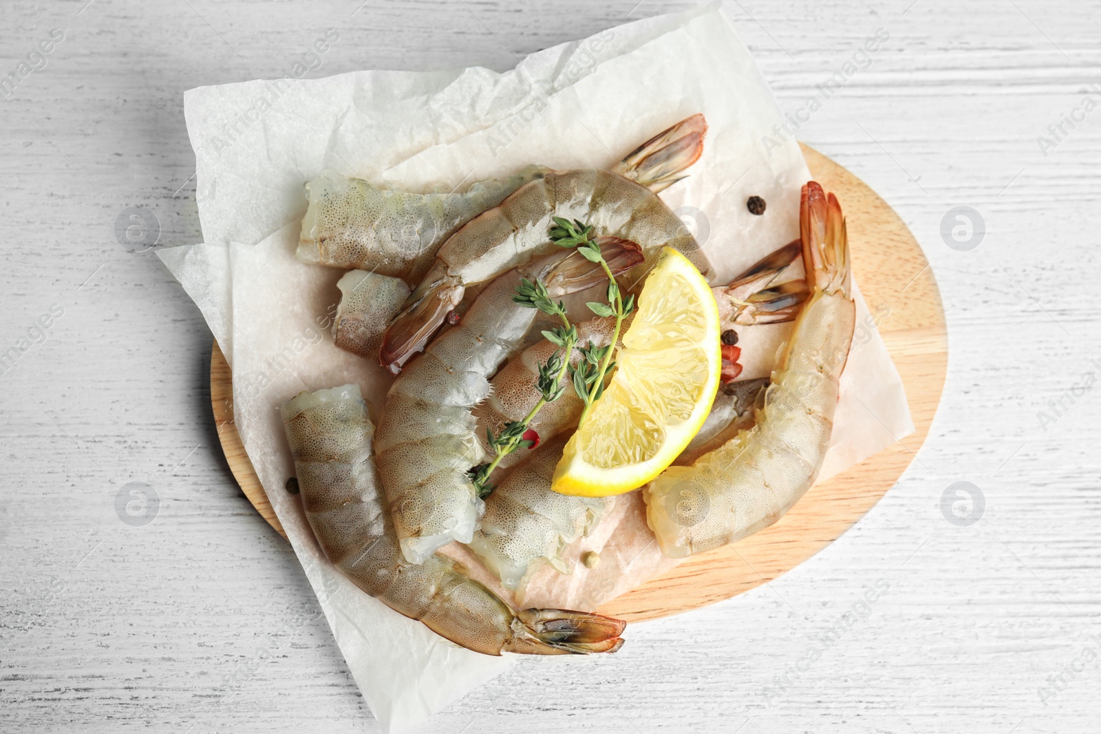 Photo of Fresh raw shrimps on white wooden table, top view