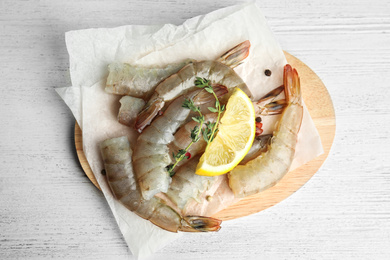 Photo of Fresh raw shrimps on white wooden table, top view