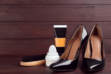 Photo of Shoe care accessories and footwear on brown wooden table