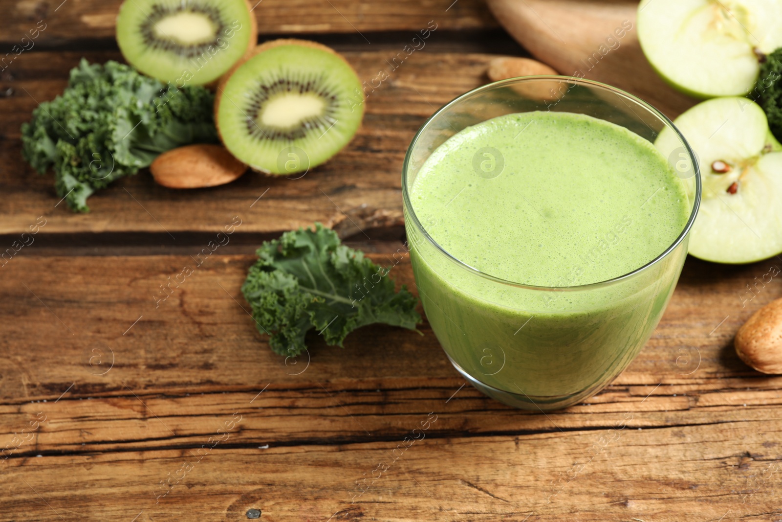 Photo of Tasty fresh kale smoothie on wooden table, closeup