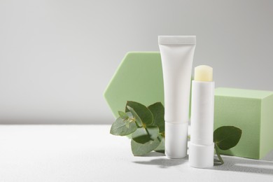 Photo of Stylish presentation of different lip balms on white table, space for text