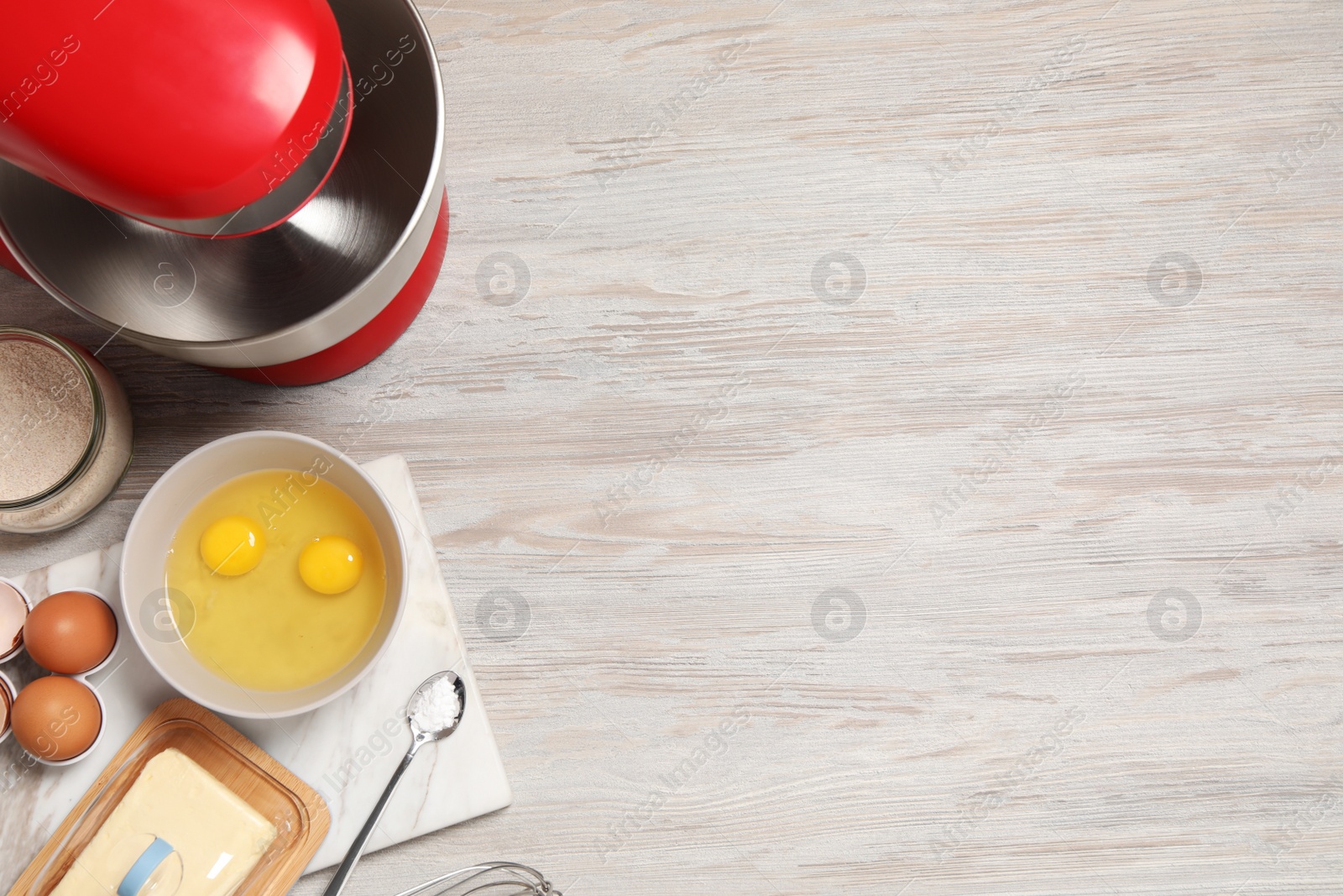 Photo of Modern red stand mixer and different ingredients on white wooden table, flat lay. Space for text