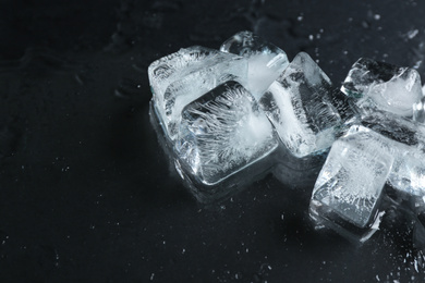 Ice cubes on wet black surface, closeup