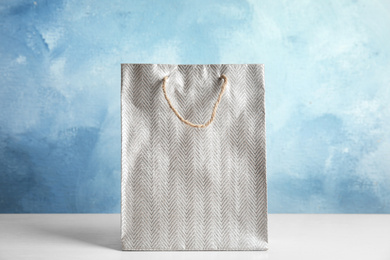 Silver shopping paper bag on white table