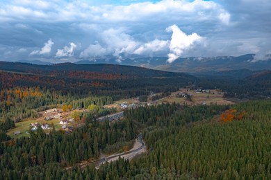 Image of Aerial view of mountain forest and village on autumn day