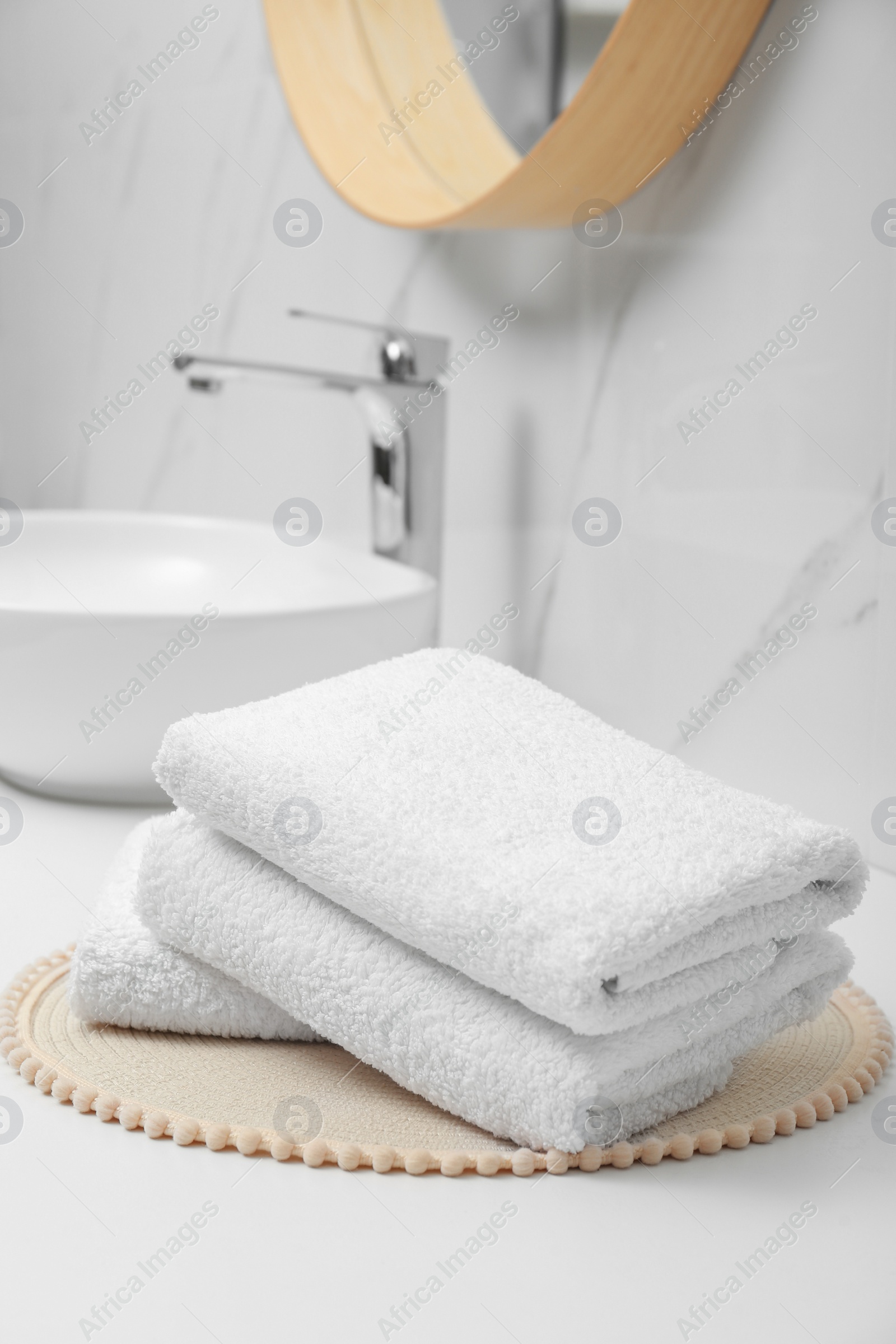 Photo of Folded bath towels on white table in bathroom