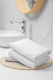 Photo of Folded bath towels on white table in bathroom