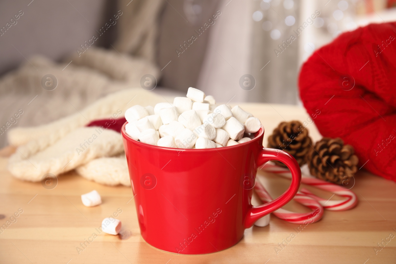 Photo of Cup of hot cocoa with marshmallows on wooden table indoors. Winter drink