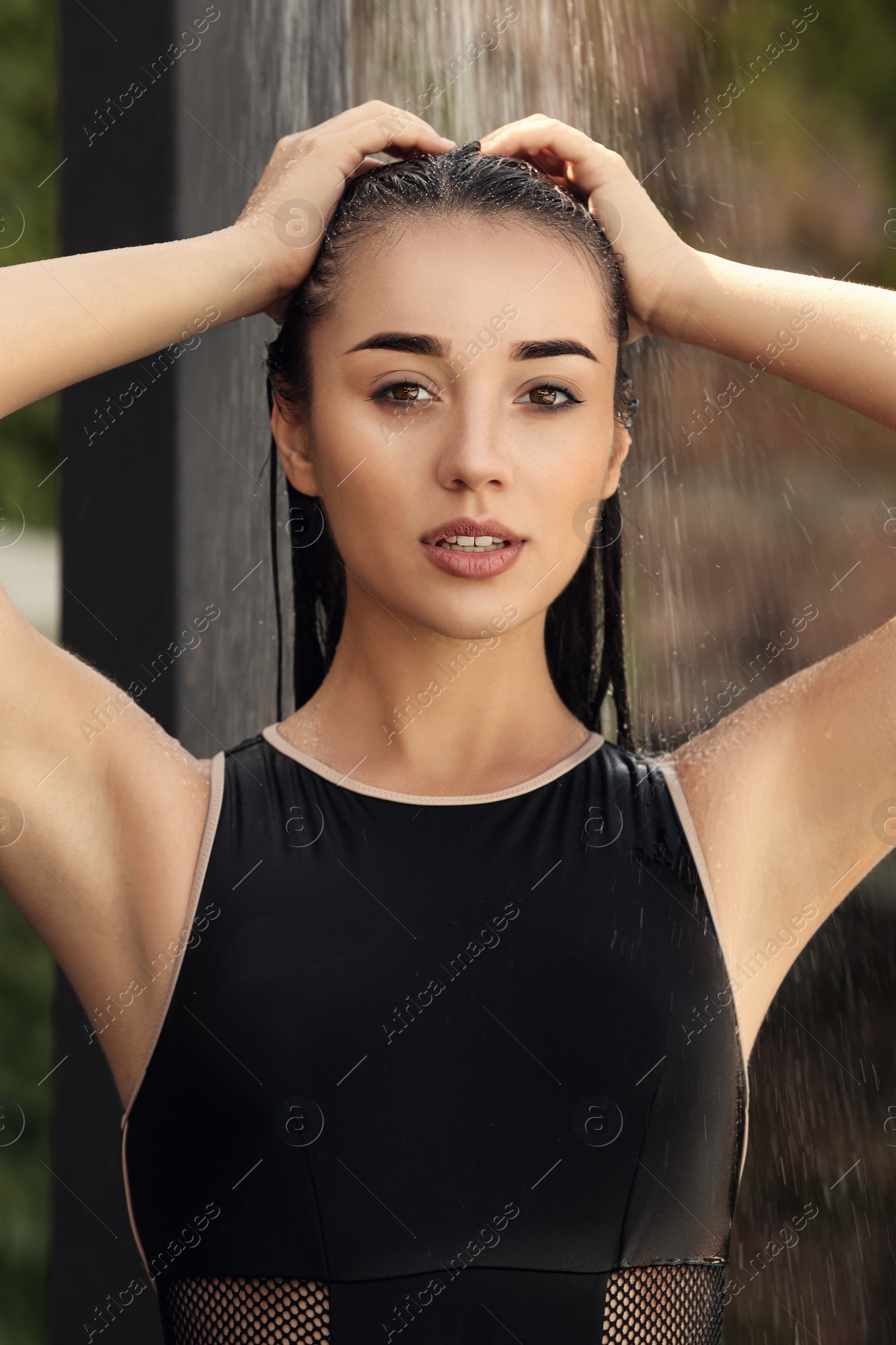 Photo of Woman washing hair in outdoor shower on summer day