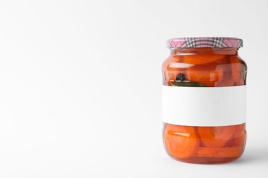 Photo of Jar of pickled sliced carrots with blank label on white background