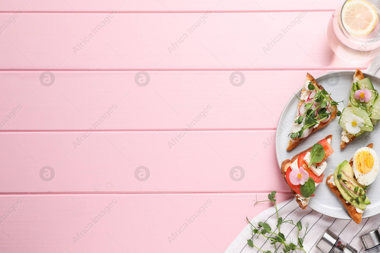 Photo of Different tasty sandwiches served on pink wooden table, flat lay. Space for text