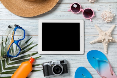 Photo of Flat lay composition with beach objects and tablet on wooden background