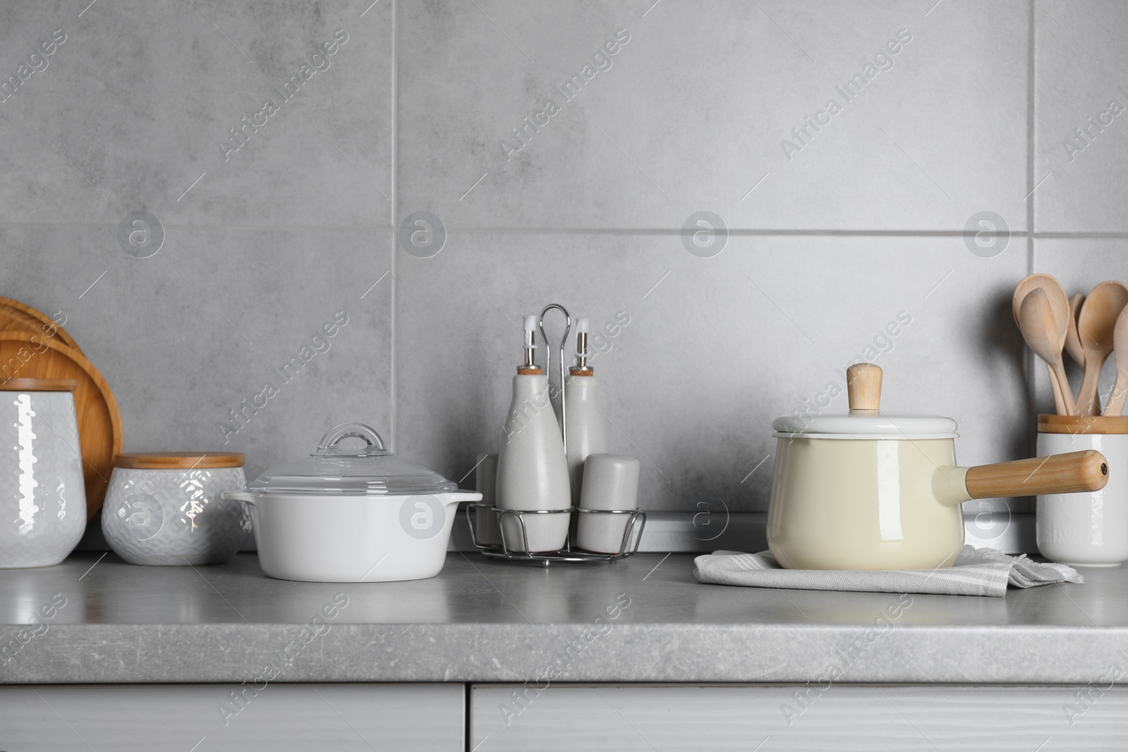 Photo of Set of different cooking utensils on grey countertop in kitchen