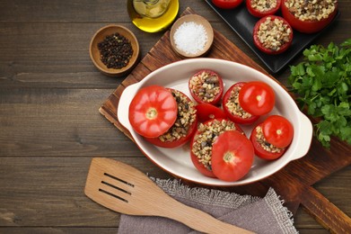 Delicious stuffed tomatoes with minced beef, bulgur and mushrooms on wooden table, flat lay. Space for text