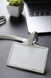 Photo of Blank badge, laptop and houseplant on grey background