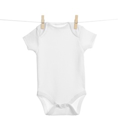 Photo of Baby onesie hanging on clothes line against white background. Laundry day