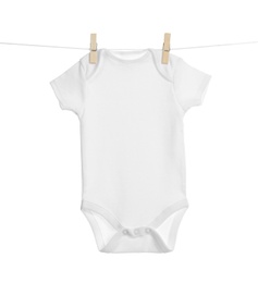 Baby onesie hanging on clothes line against white background. Laundry day