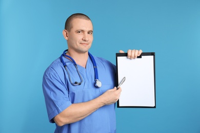 Photo of Portrait of medical assistant with stethoscope and clipboard on color background. Space for text