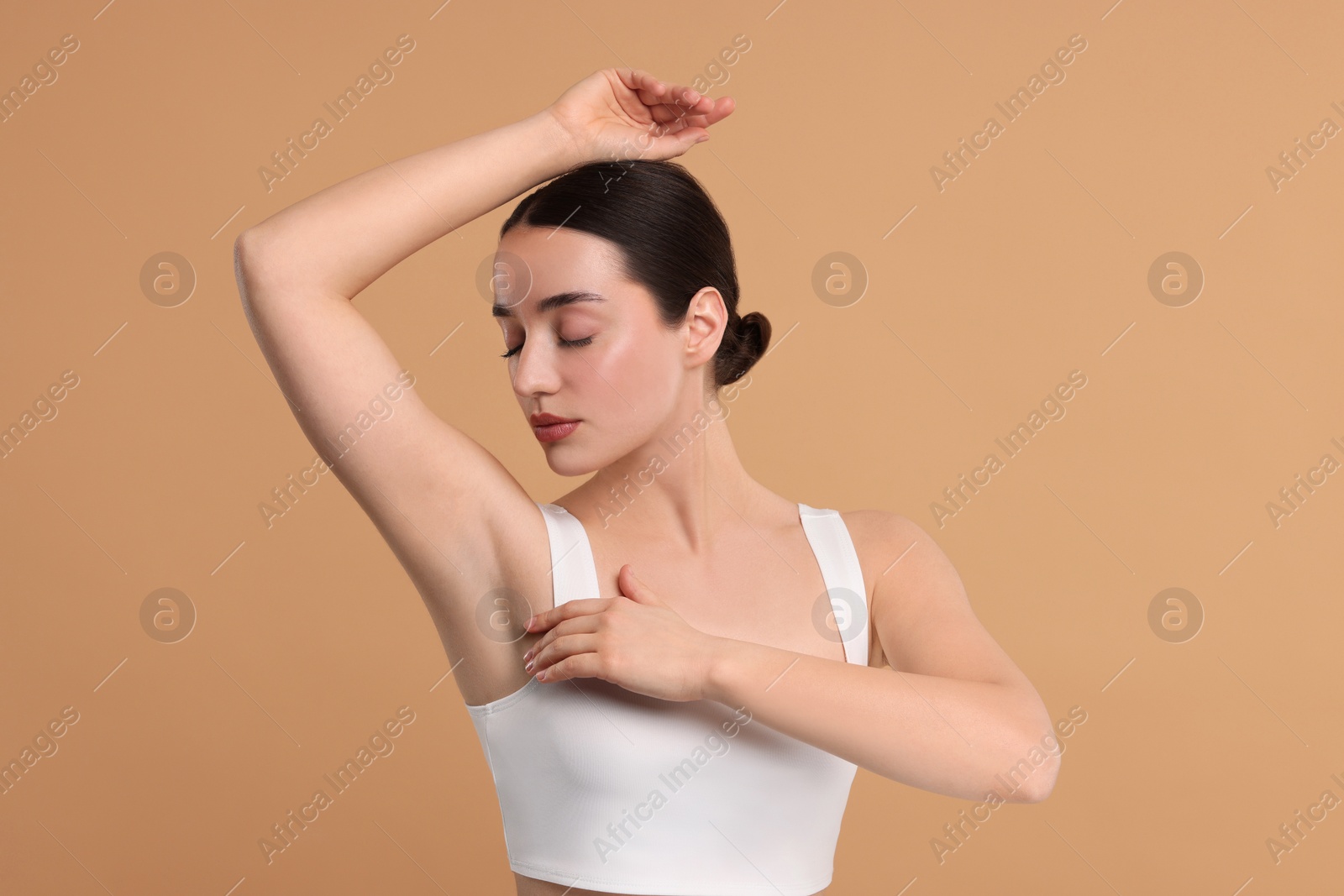 Photo of Beautiful woman showing armpit with smooth clean skin on beige background