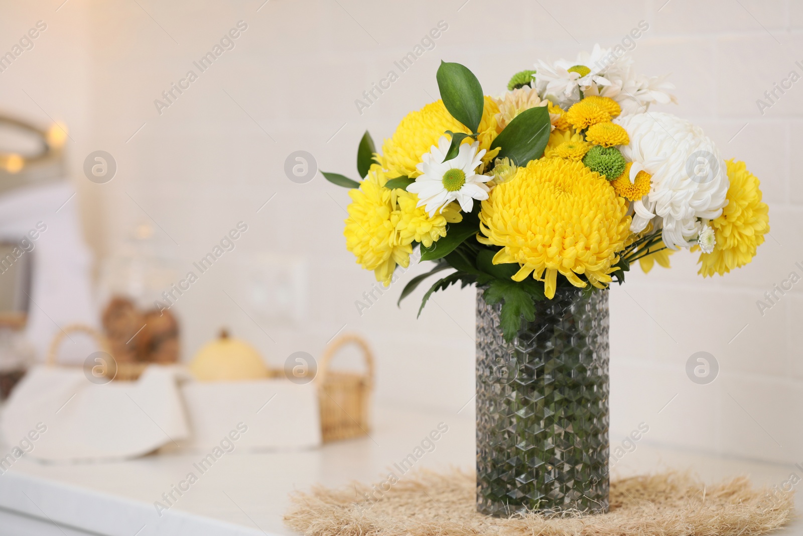 Photo of Bouquet of beautiful chrysanthemum flowers on countertop in kitchen, space for text