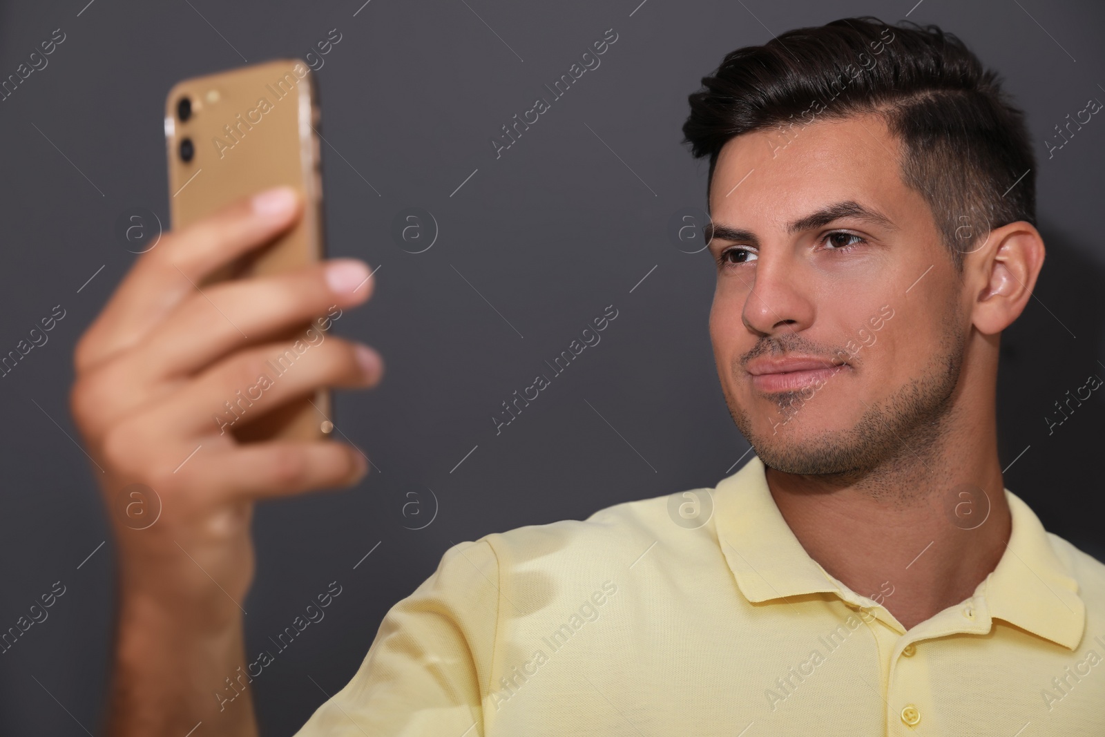 Photo of Man unlocking smartphone with facial scanner on grey background. Biometric verification