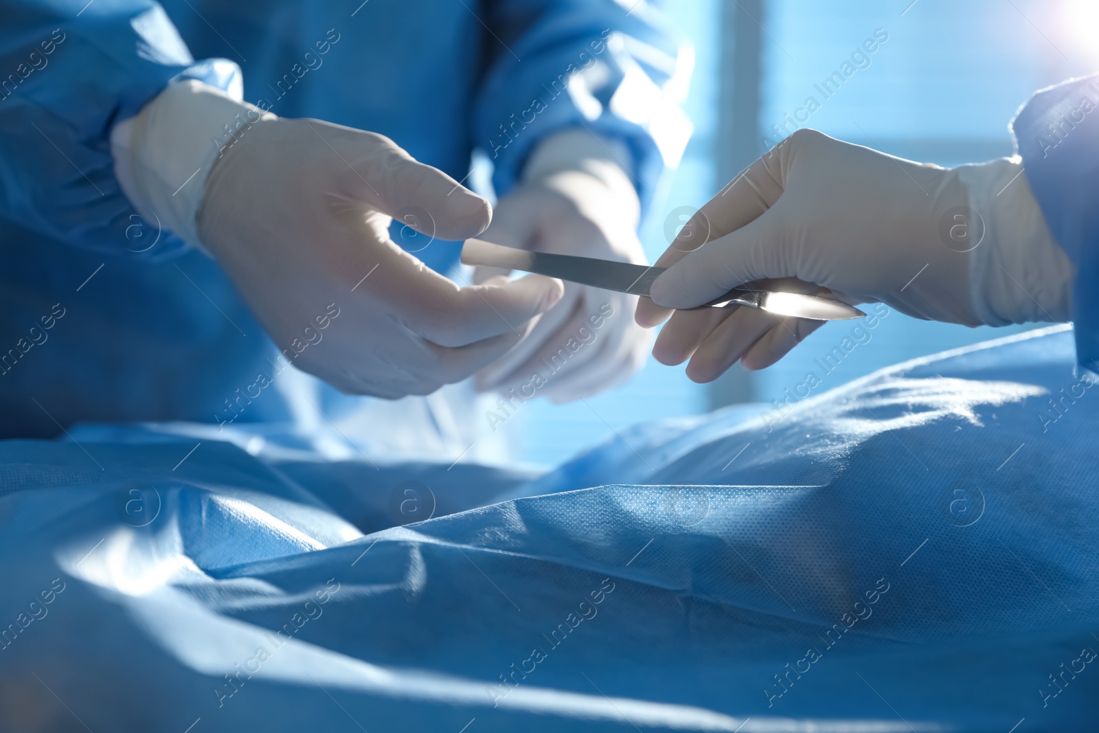 Photo of Professional surgeons with instruments performing operation in clinic, closeup