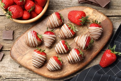 Delicious chocolate covered strawberries on wooden table, flat lay