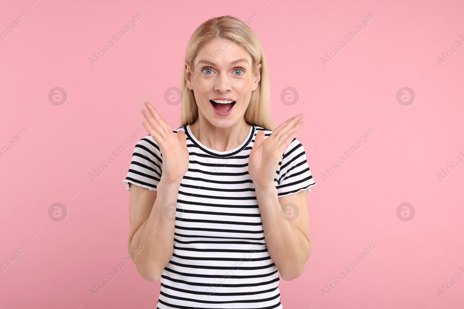 Photo of Portrait of surprised woman on pink background