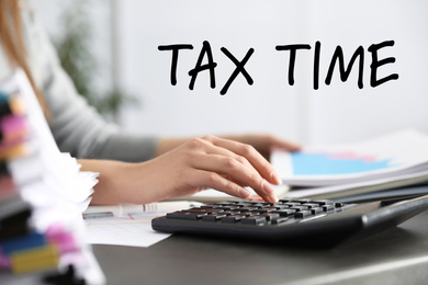 Image of Tax accountant working with calculator and documents at table, closeup