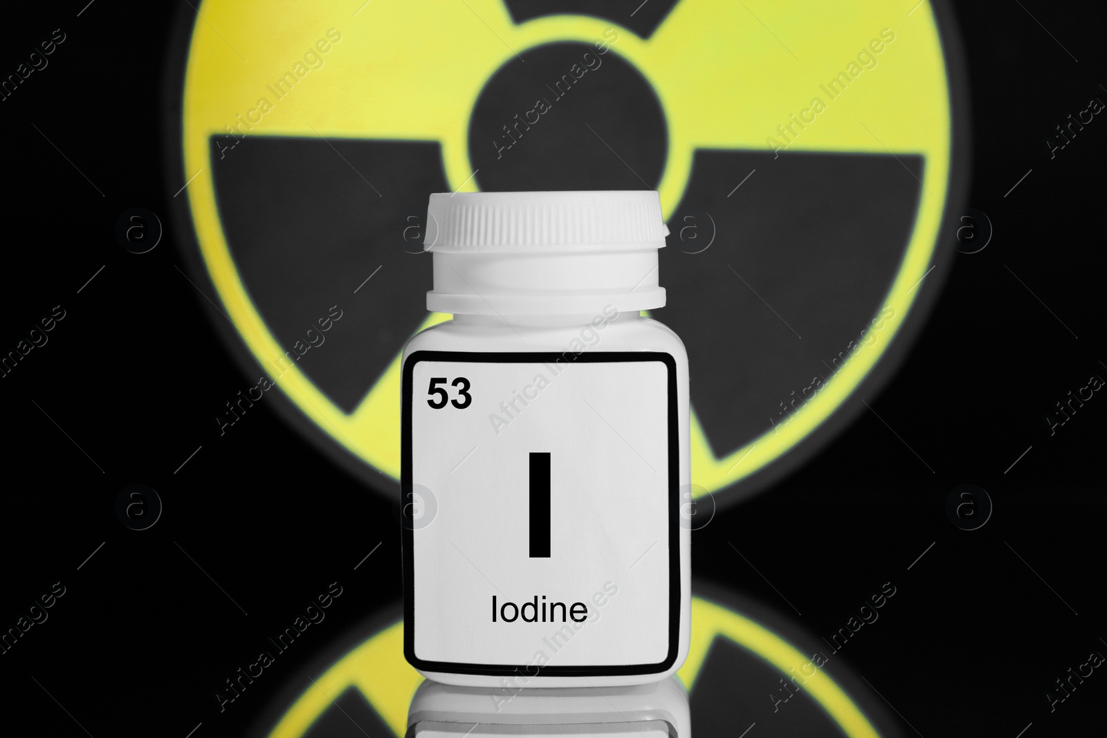 Photo of Bottle of medical iodine and radiation sign on black background, color tone effect