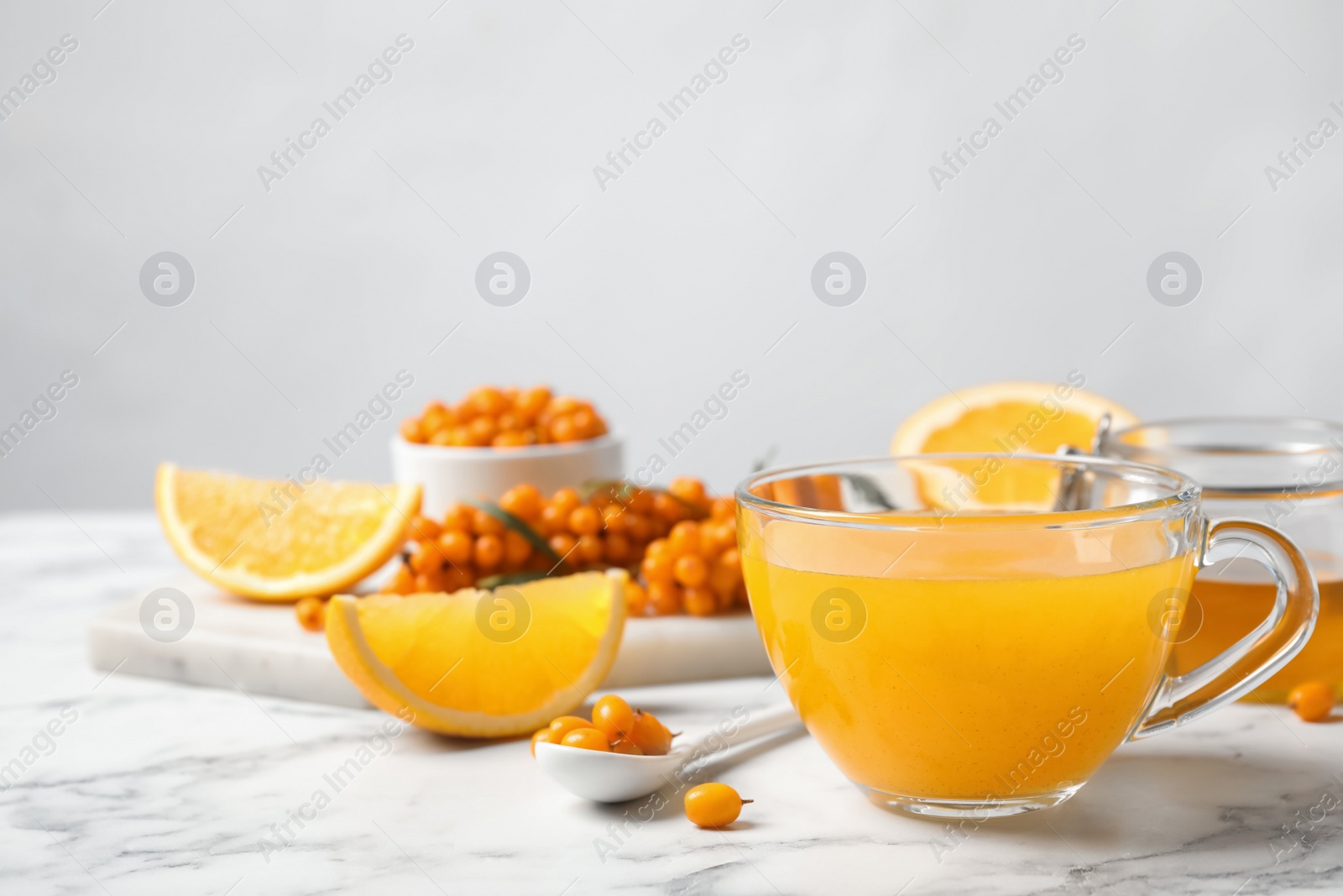 Photo of Fresh sea buckthorn tea on white marble table