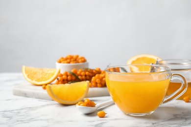 Fresh sea buckthorn tea on white marble table