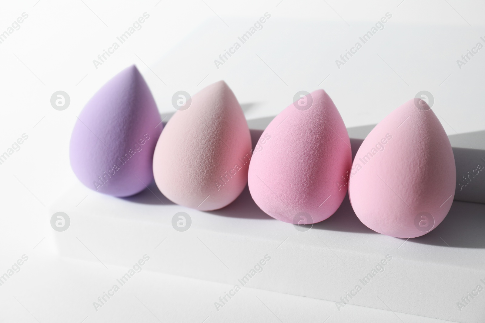 Photo of Stylish presentation of makeup sponges on white background