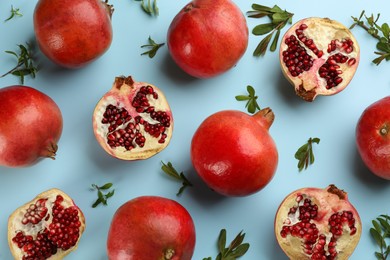 Photo of Flat lay composition with ripe pomegranates on light blue background