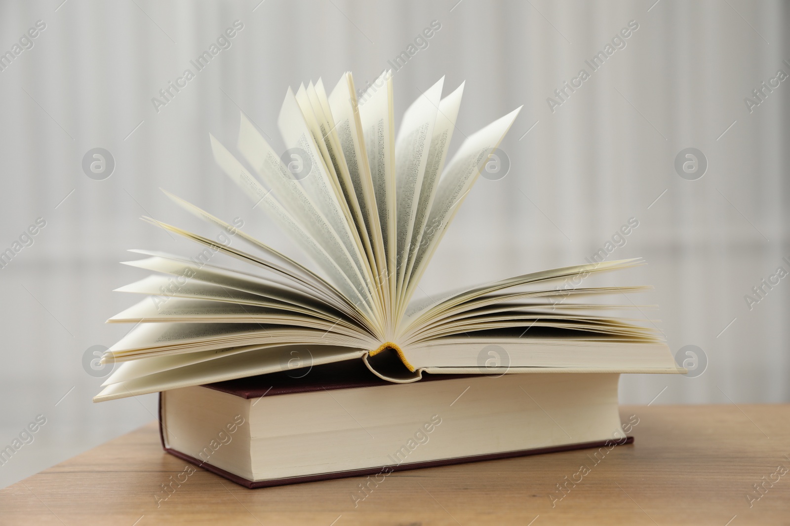 Photo of Different hardcover books on wooden table indoors