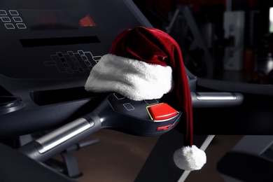 Santa hat on fitness treadmill in modern gym