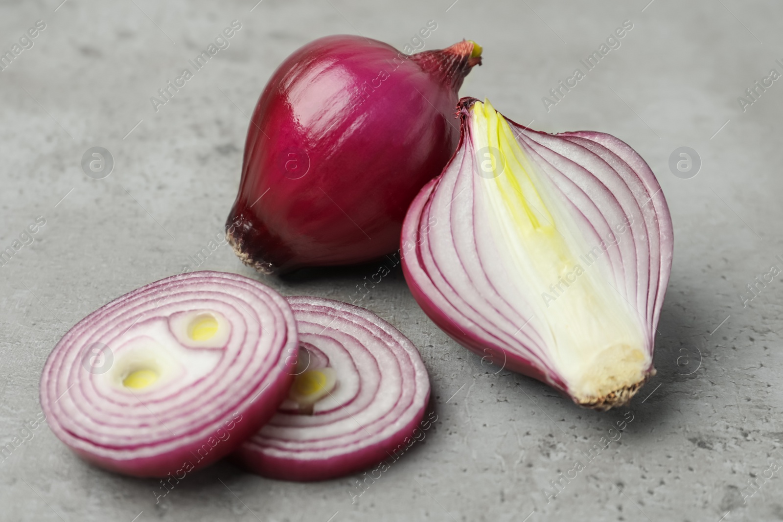 Photo of Fresh red onion on light grey table, closeup