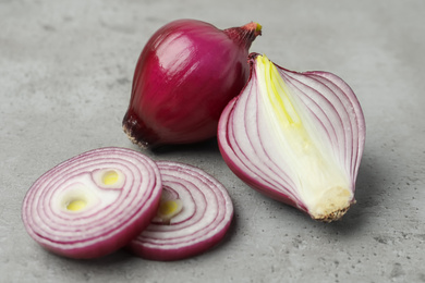 Photo of Fresh red onion on light grey table, closeup