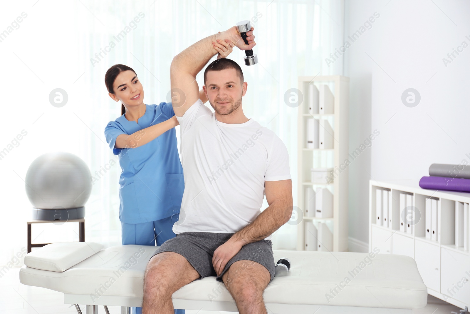 Photo of Doctor working with patient in hospital. Rehabilitation exercises